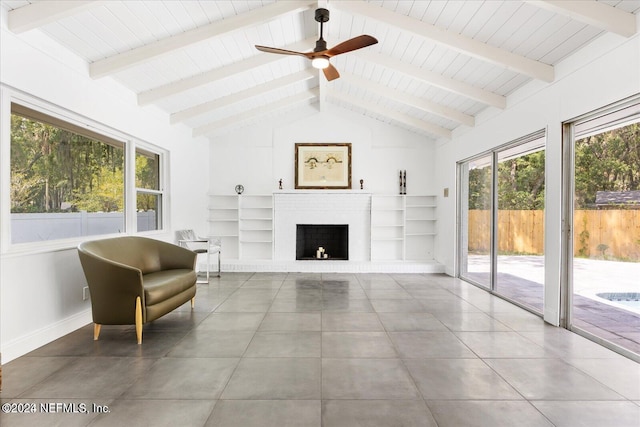 interior space featuring a fireplace, beam ceiling, high vaulted ceiling, and ceiling fan