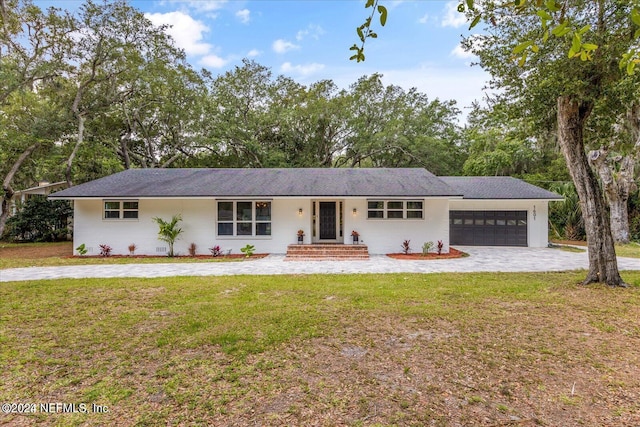 single story home with a garage and a front lawn