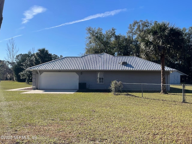 view of side of property with central AC unit, a garage, and a lawn