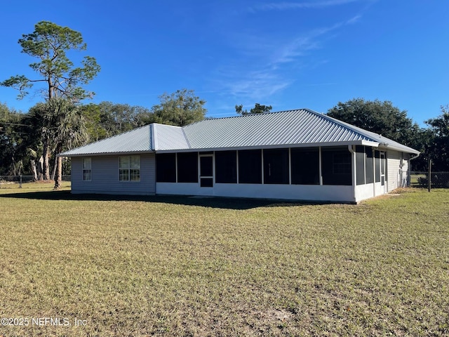 back of property with a yard and a sunroom