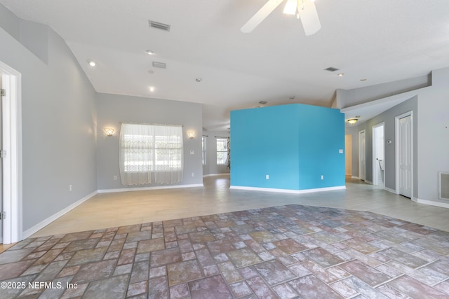 empty room with ceiling fan and vaulted ceiling