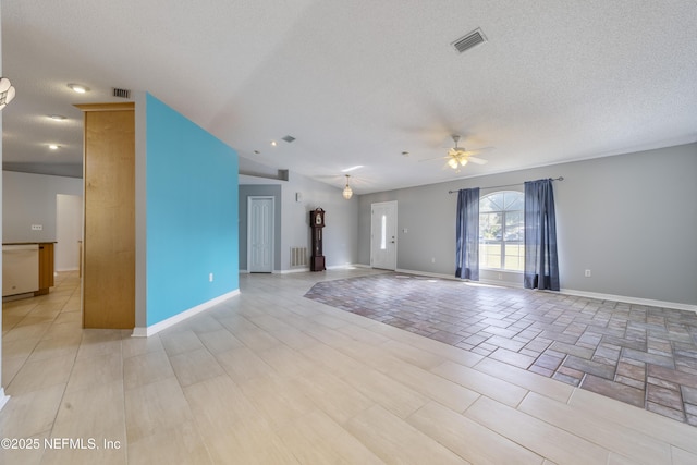 unfurnished room with a textured ceiling, ceiling fan, and lofted ceiling