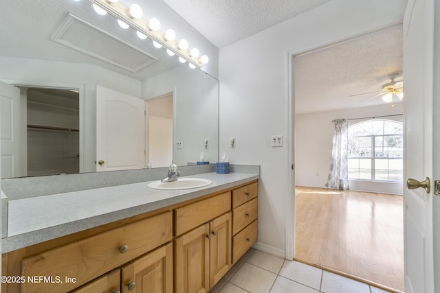 bathroom featuring ceiling fan, a textured ceiling, tile patterned floors, and vanity