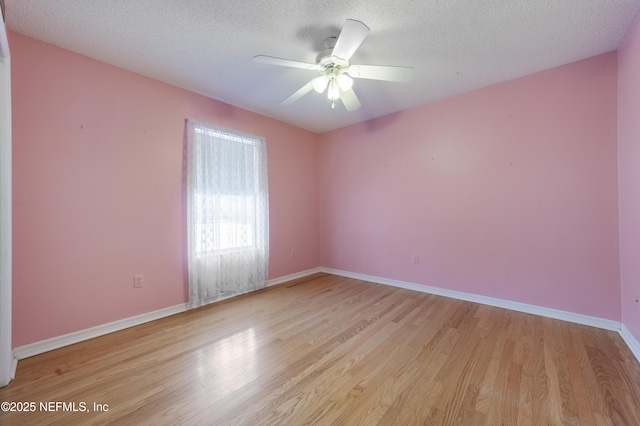 unfurnished room with ceiling fan, light wood-type flooring, and a textured ceiling