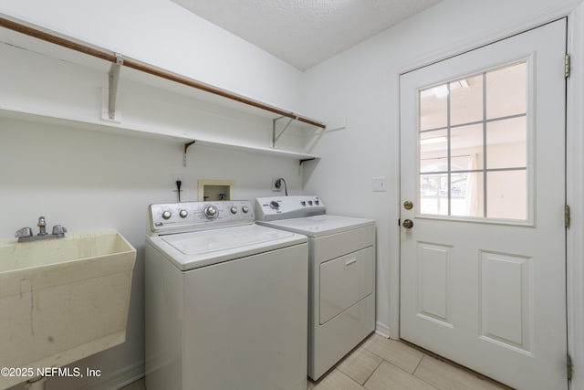 clothes washing area with sink, plenty of natural light, washing machine and dryer, and light tile patterned flooring