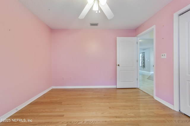 unfurnished room featuring ceiling fan, a textured ceiling, and light wood-type flooring