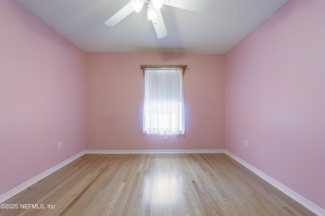 spare room with a textured ceiling, ceiling fan, and light hardwood / wood-style flooring