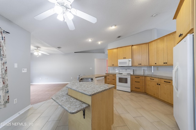 kitchen with light brown cabinetry, sink, white appliances, and vaulted ceiling