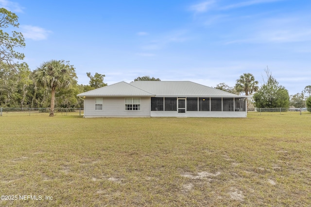 rear view of property with a sunroom and a yard