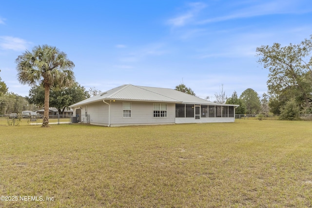 rear view of house with a sunroom and a yard