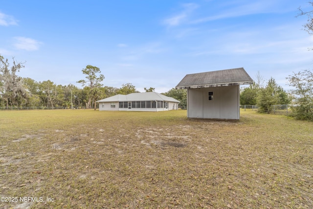 view of yard with a sunroom and a storage shed