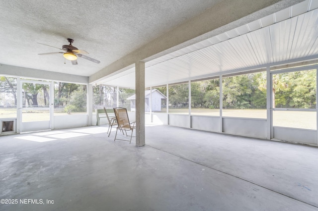 unfurnished sunroom featuring ceiling fan