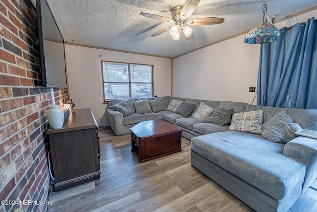 living room with light wood-type flooring, a textured ceiling, and crown molding