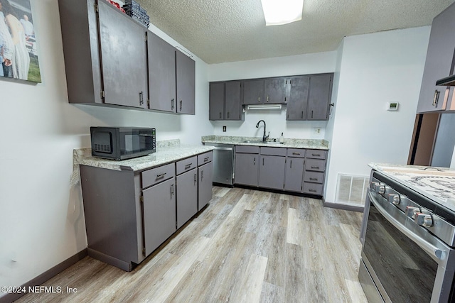 kitchen featuring a sink, visible vents, light countertops, range, and dishwasher