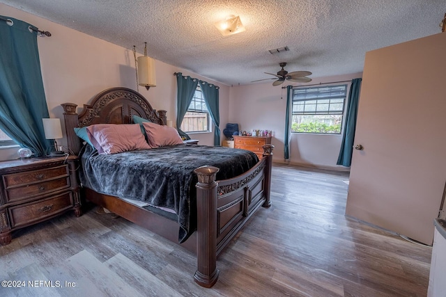 bedroom featuring a textured ceiling, wood finished floors, and visible vents