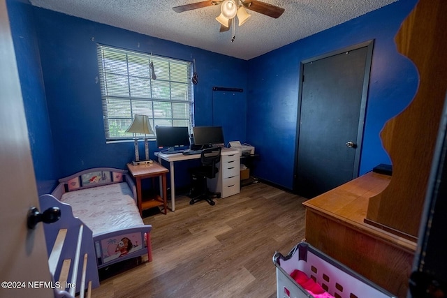 home office featuring a textured ceiling, wood finished floors, and a ceiling fan