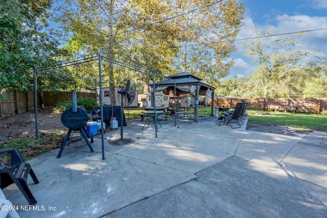 view of patio featuring a storage shed, a fenced backyard, an outbuilding, and a gazebo