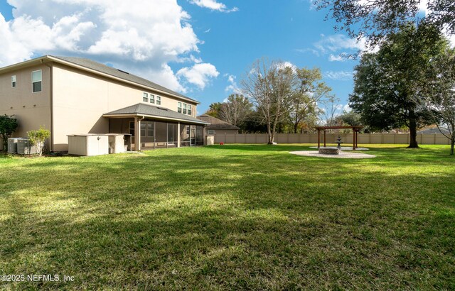 view of yard with central AC unit, an outdoor fire pit, and a sunroom