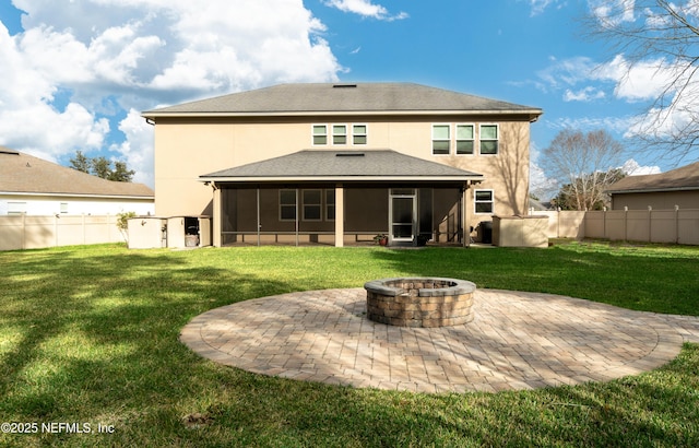 back of property with a patio area, a sunroom, a yard, and an outdoor fire pit