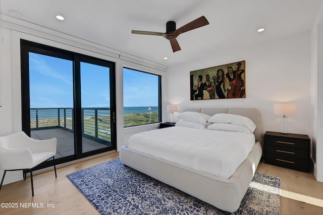 bedroom with access to outside, a water view, ceiling fan, and light hardwood / wood-style floors