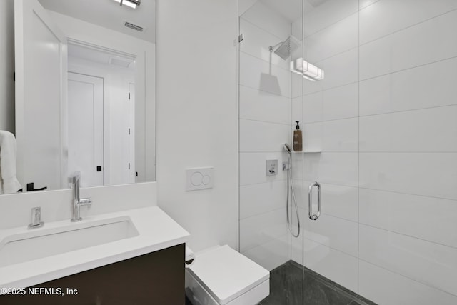 bathroom featuring vanity, toilet, and a shower with shower door