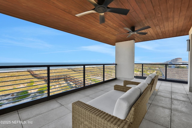 balcony featuring a water view and ceiling fan