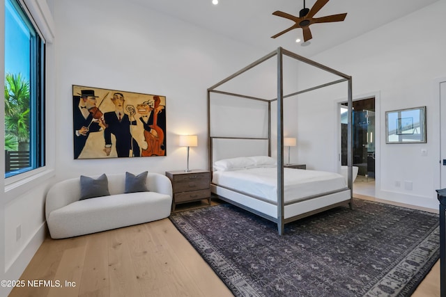 bedroom featuring hardwood / wood-style flooring, ceiling fan, lofted ceiling, and connected bathroom