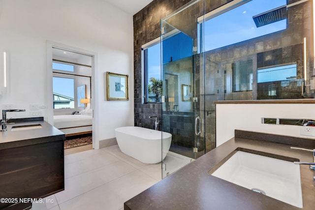 bathroom with tile patterned floors, vanity, and shower with separate bathtub