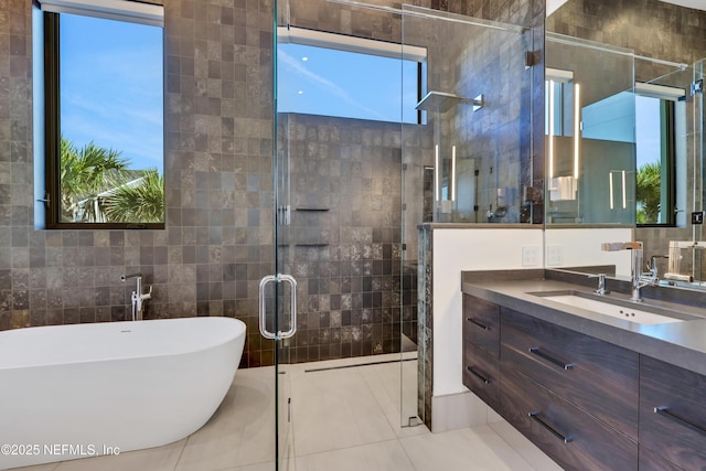 bathroom featuring tile patterned flooring, vanity, shower with separate bathtub, and tile walls