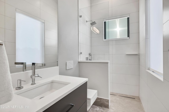 bathroom featuring a tile shower and vanity