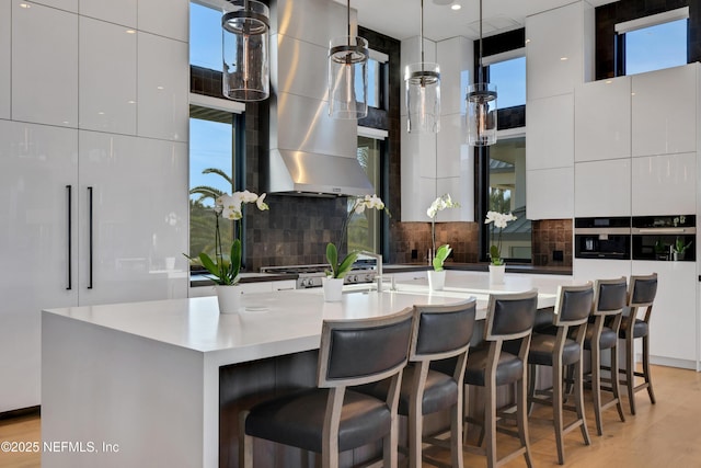 kitchen with white cabinets, a large island, and decorative light fixtures