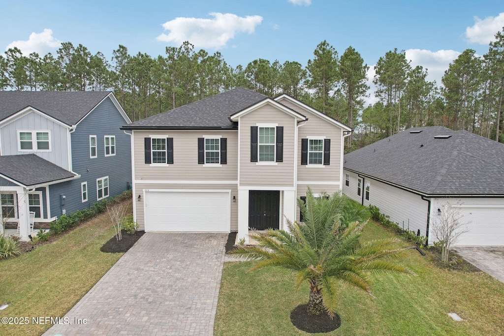 view of front of house featuring a front lawn and a garage