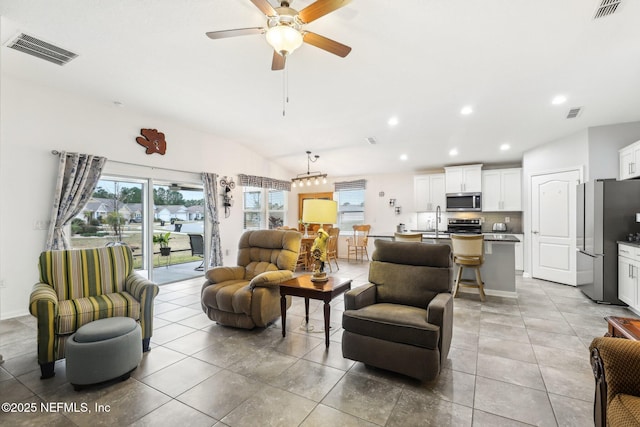 living room featuring ceiling fan, sink, and vaulted ceiling