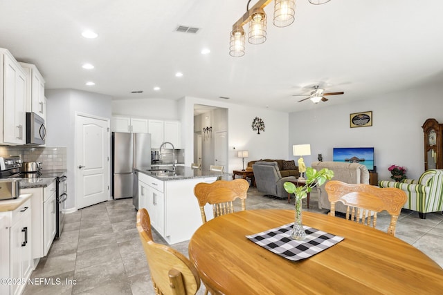 dining area with ceiling fan and sink