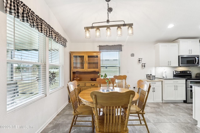 dining area with plenty of natural light and lofted ceiling