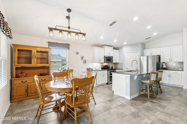 dining room featuring sink and vaulted ceiling