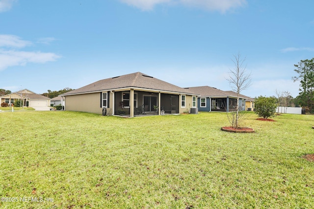 rear view of property featuring a sunroom and a yard