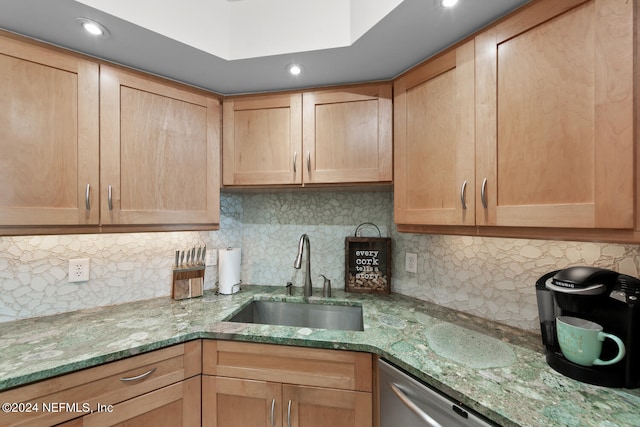 kitchen featuring tasteful backsplash, light stone countertops, sink, and dishwasher