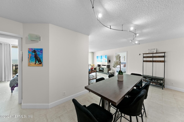 dining area featuring a textured ceiling and track lighting