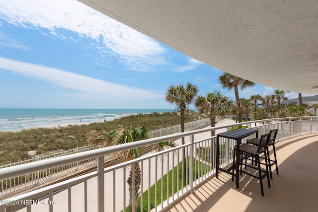 balcony featuring a beach view and a water view