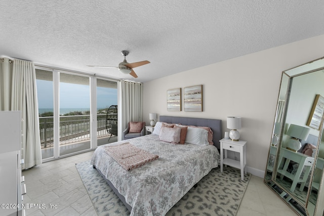 bedroom featuring a textured ceiling, access to outside, floor to ceiling windows, and ceiling fan