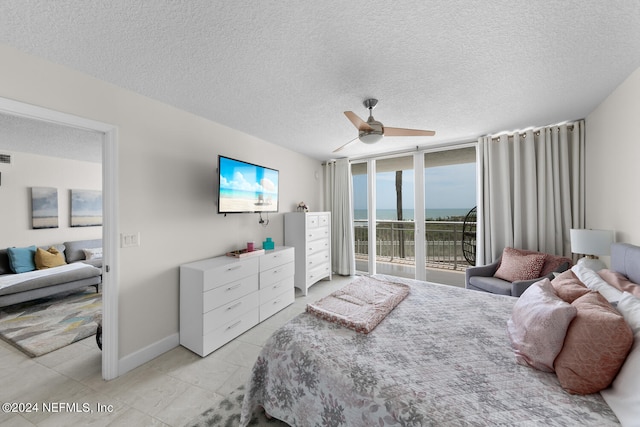 bedroom featuring access to exterior, a textured ceiling, floor to ceiling windows, and ceiling fan