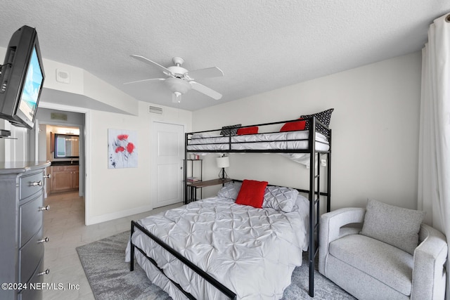 bedroom with ceiling fan and a textured ceiling