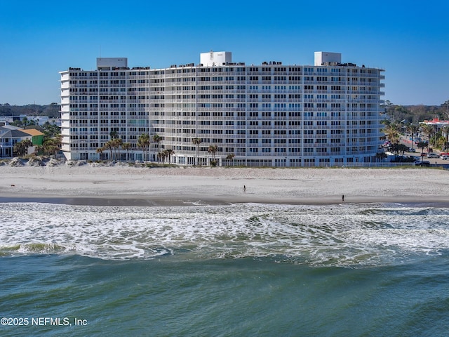 view of property with a water view and a beach view