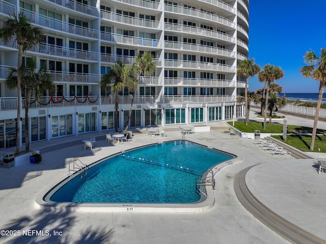 view of pool featuring a patio and a water view