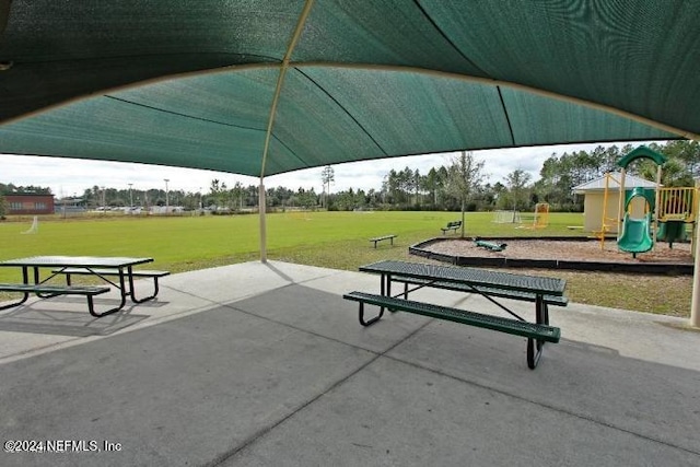 view of property's community with a playground and a lawn