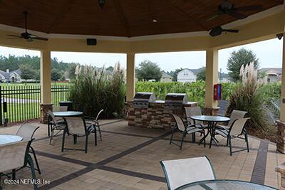 view of patio / terrace featuring exterior kitchen, a gazebo, and ceiling fan