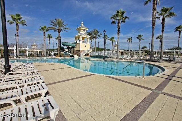 view of pool with a water slide and a patio area