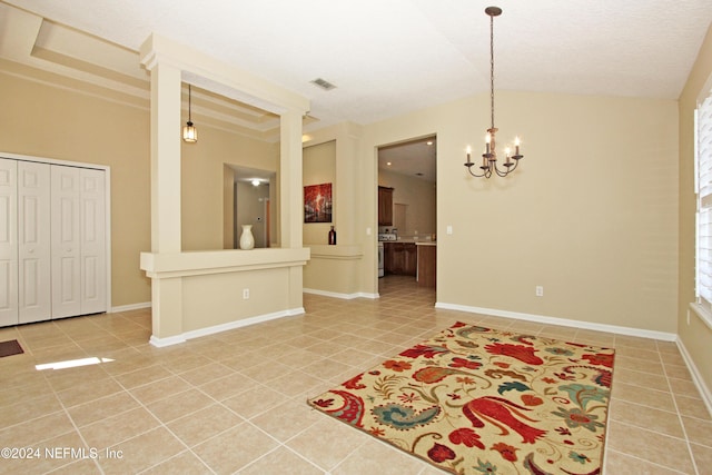 tiled spare room with a notable chandelier