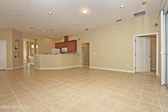 unfurnished living room featuring light tile patterned flooring and a textured ceiling